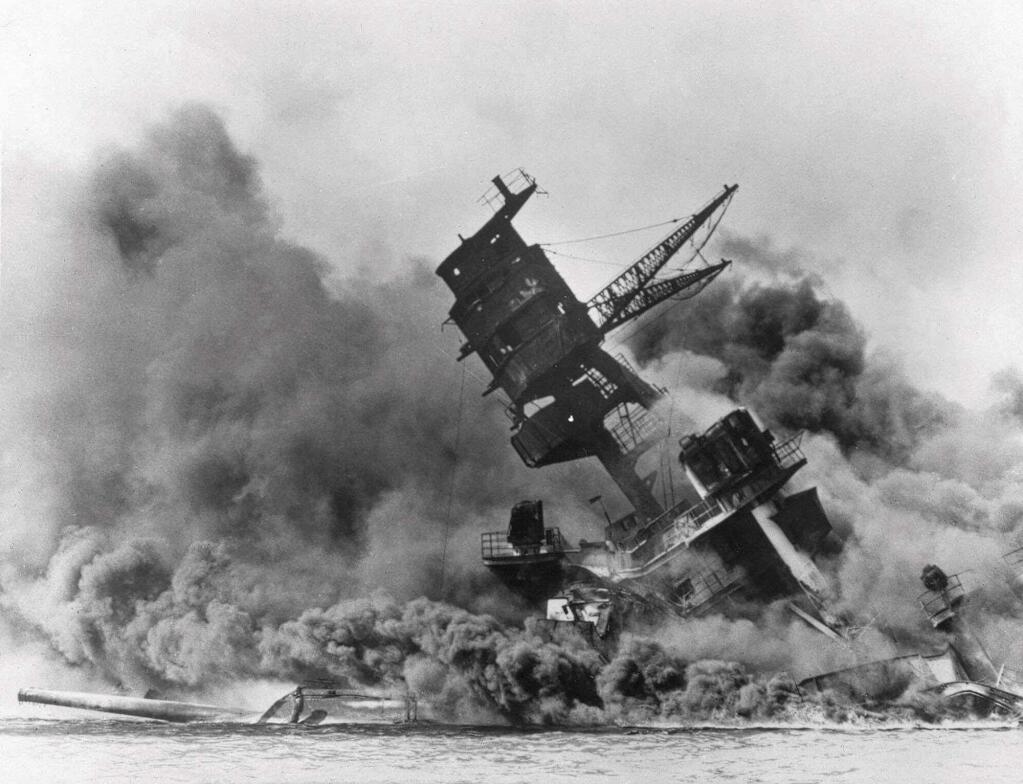 FILE - In this Dec. 7, 1941 file photo, smoke rises from the battleship USS Arizona as it sinks during the Japanese attack on Pearl Harbor, Hawaii. Divers will place the ashes of Lauren Bruner, a survivor from the USS Arizona in Pearl Harbor, in the wreckage of his ship during a ceremony this weekend. Bruner died earlier in 2019 at the age of 98. (AP Photo, File)