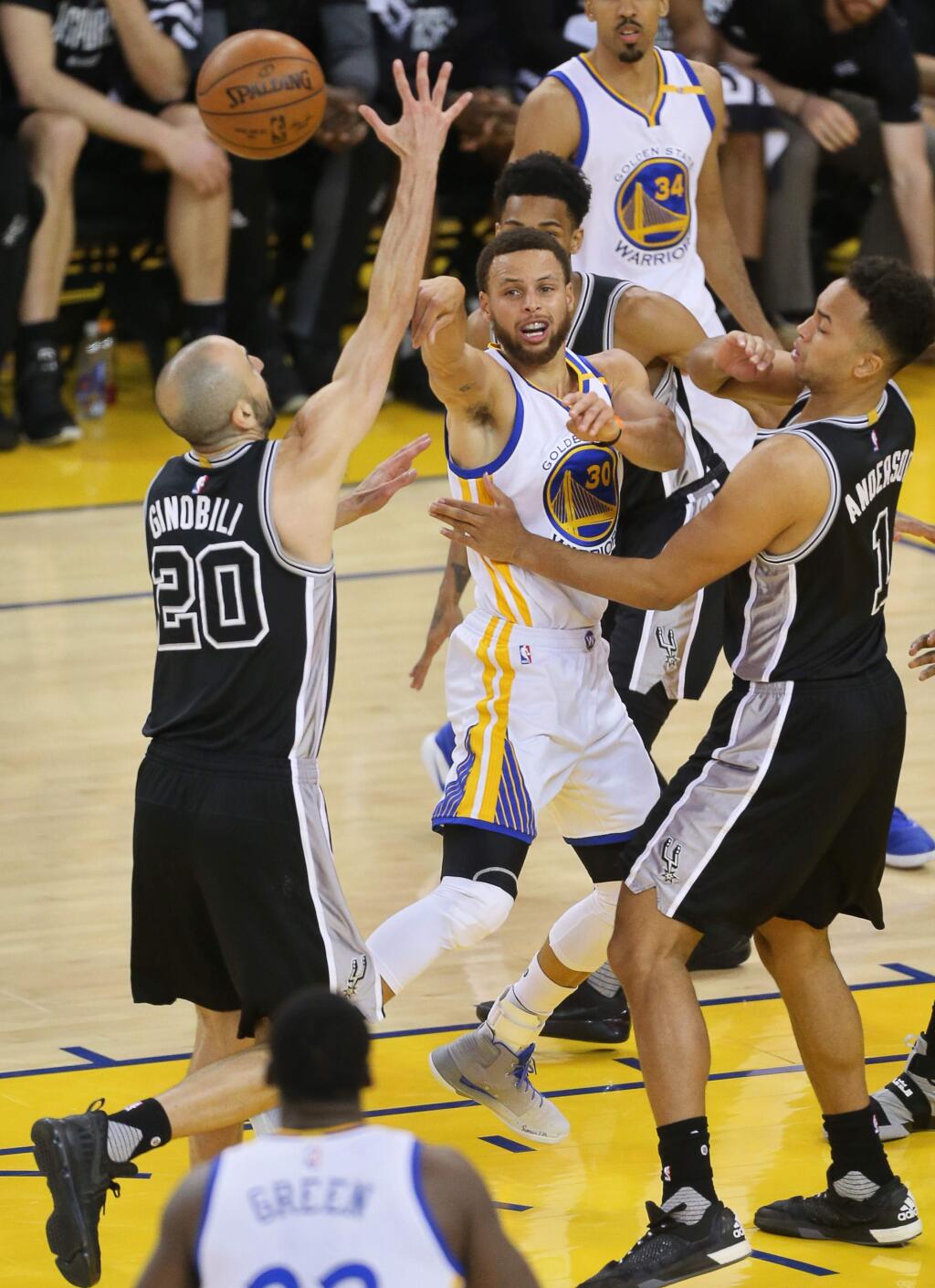 Golden State Warriors guard Stephen Curry passes the ball around San Antonio Spurs guard Manu Ginobili and guard Kyle Anderson, during game 2 of the NBA Western Conference Finals in Oakland on Tuesday, May 16, 2017. (Christopher Chung/ The Press Democrat)