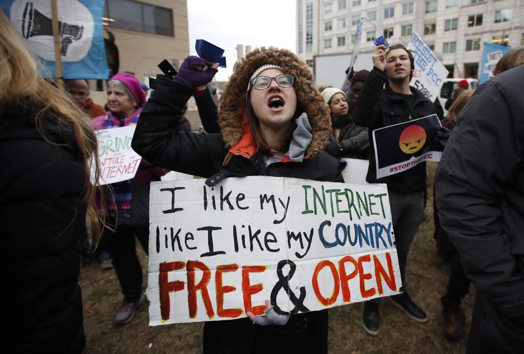 FILE - In this Dec. 14, 2017 file photo, Lindsay Chestnut of Baltimore holds a sign that reads 'I like My Internet Like I Like my Country: Free & Open' as she protests near the Federal Communications Commission (FCC), in Washington where the FCC was scheduled to meet and vote on net neutrality. On Tuesday, March 13, 2018, a California lawmaker introduced legislation that looks to maintain net-neutrality rules recently scuttled by the Federal Communications Commission, setting up a likely showdown with influential internet companies and, if his bill passes, with the Trump administration in court. (AP Photo/Carolyn Kaster, File)