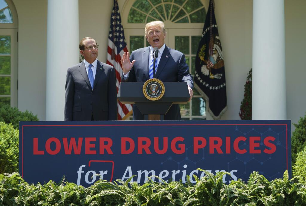 President Donald Trump, accompanied by Health and Human Services Secretary Alex Azar, makes an announcement in the White House rose garden about a plan to address high drug prices under Medicare Part D. (CAROLYN KASTER / Associated Press)