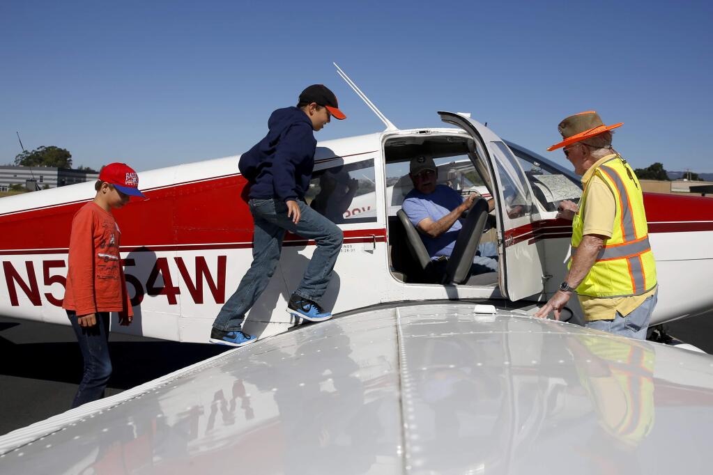 Kiel Smit, 11, followed by his brother Jayden, 9, climbs aboard a Piper PA-28 Cherokee piloted by Don Booker and assisted by BK White, right, as part of the Young Eagles program at Sonoma Skypark on Sunday, July 8, 2018, in Sonoma, California. (BETH SCHLANKER/ PD)