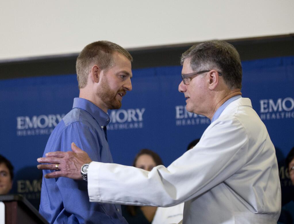 Ebola victim Dr. Kent Brantly, left, embraces Dr. Bruce Ribner medical director of Emory's Infectious Disease Unit, after being released from Emory University Hospital, Thursday, Aug. 21, 2014, in Atlanta. (AP Photo/John Bazemore)