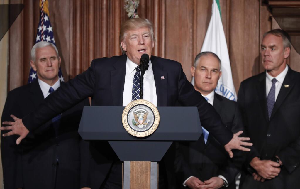 President Donald Trump, accompanied by from left, Vice President Mike Pence, Environmental Protection Agency (EPA) Administrator Scott Pruitt, and Interior Secretary Ryan Zinke, speaks at EPA headquarters in Washington, Tuesday, March 28, 2017, prior to signing an Energy Independence Executive Order. Trump signed an executive order aimed at moving forward on his campaign pledge to unravel former President Barack Obama's plan to curb global warming. (AP Photo/Pablo Martinez Monsivais)