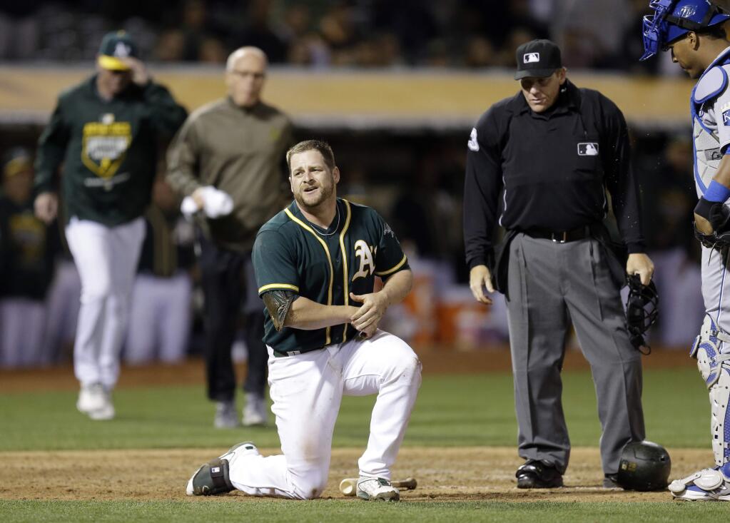 Oakland Athletics' Stephen Vogt holds his arm after being hit by a pitch thrown by Kansas City Royals' Franklin Morales during the ninth inning of a game Friday, June 26, 2015, in Oakland. (AP Photo/Ben Margot)