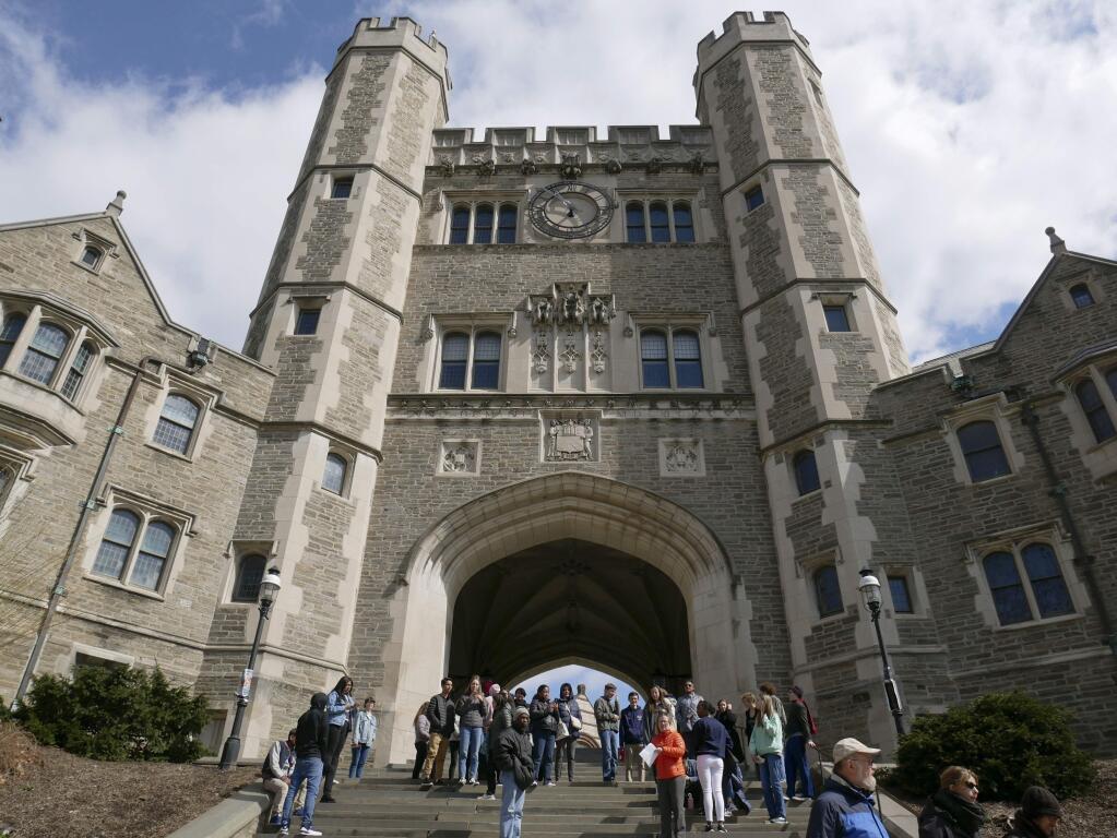 FILE - In this April 5, 2018, file photo, people walk through the Princeton University campus in Princeton, N.J. Princeton University said it would reject federal relief money available in the government's multi-trillion dollar coronavirus rescue package. (AP Photo/Seth Wenig, File)