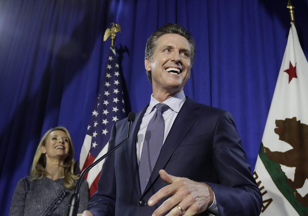 Democratic Lt. Gov. Gavin Newsom, right, speaks at his gubernatorial campaign's primary night watch party next to his wife Jennifer Siebel Newsom in San Francisco, Tuesday, June 5, 2018. (AP Photo/Jeff Chiu)