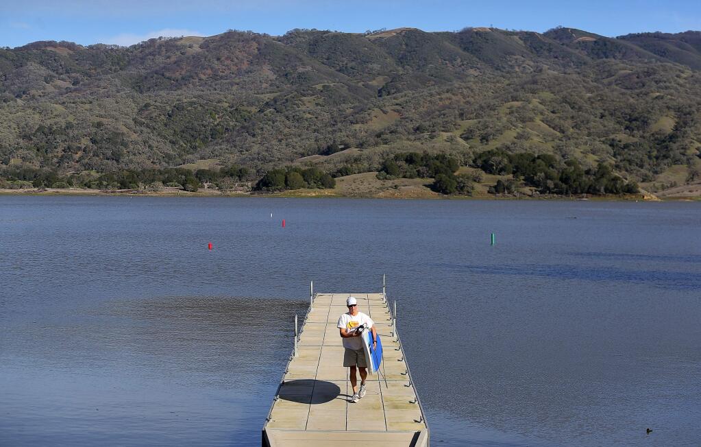 George Spinas walks his stand-up paddleboard up the dock at the south boat ramp of Lake Mendocino, in Ukiah, on Monday, Feb. 1, 2016. (Christopher Chung / The Press Democrat)