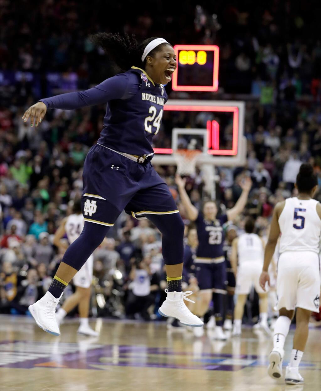 Notre Dame's Arike Ogunbowale (24) celebrates as Connecticut's Crystal Dangerfield (5) walks away as time expires in overtime in the semifinals of the women's NCAA Final Four, Friday, March 30, 2018, in Columbus, Ohio. Notre Dame won 91-89. (AP Photo/Tony Dejak)
