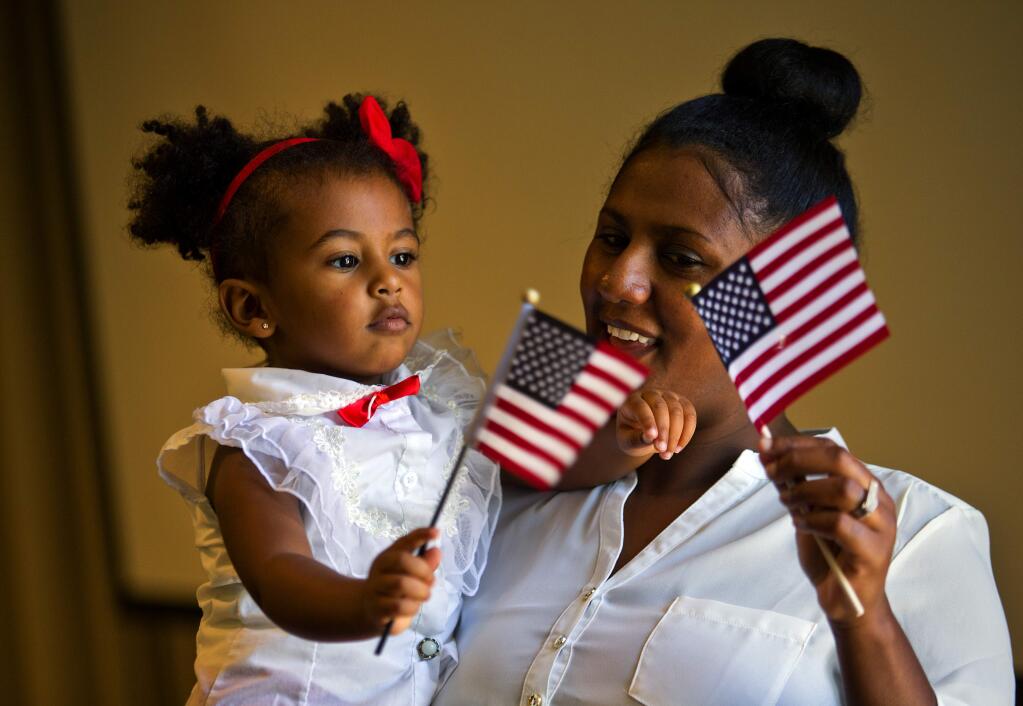 Liya Edward, who was born in Eritrea, celebrates with her daughter Bethel, 2, after being sworn in as a new citizen of the United States at a ceremony in the Sonoma County Public Library in Santa Rosa on Wednesday. (JOHN BURGESS/The Press Democrat)