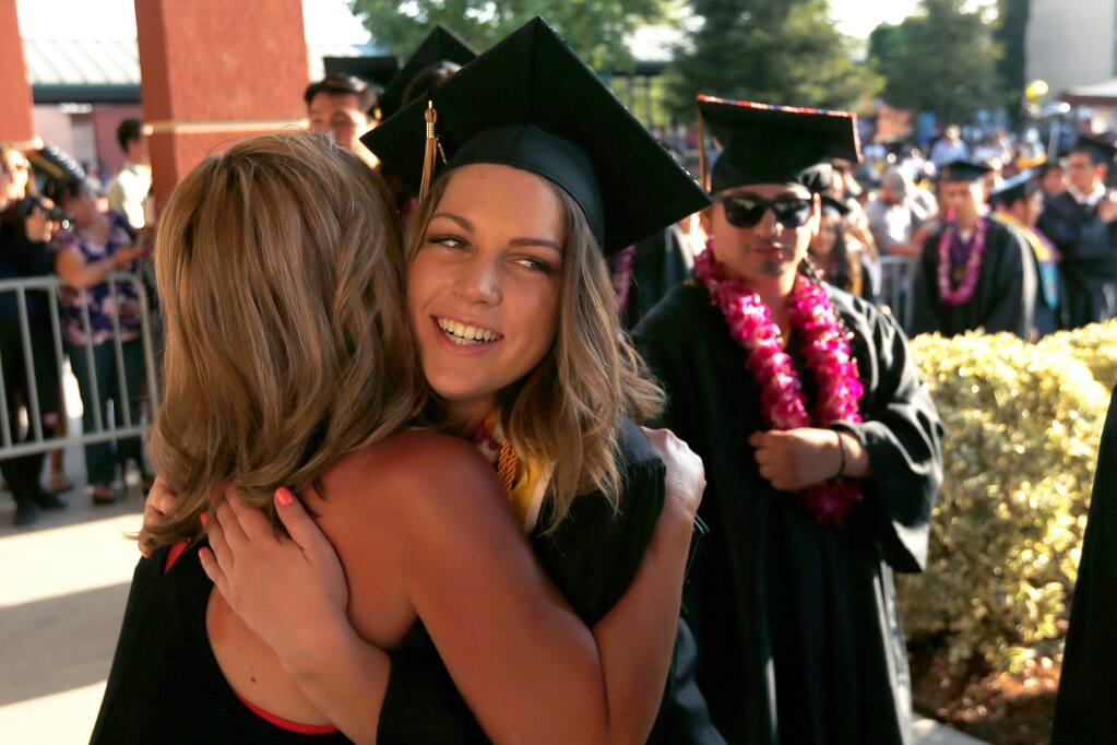Senior Alexis Fraser embraces faculty member Carrie Carstensen during Windsor High School commencement exercises in Windsor, California on Saturday, May 28, 2016. (Alvin Jornada / The Press Democrat)