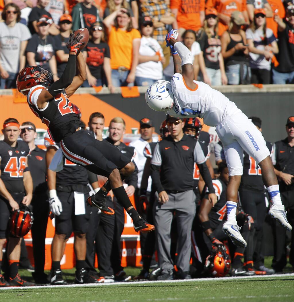 FILE - In this Sept. 24, 2016, file photo, Oregon State's Seth Collins, left, gets behind Boise State's Brandon Arnold, right, to make a catch in the second half of an NCAA college football game in Corvallis, Ore. The change in positions for Oregon State quarterback Set Collins seemed inevitable at the end of last season, when he was used in several roles in the finale against Oregon. Now Collins has embraced his new role as receiver, joining a handful of prospective QBs across the league who have made shifted positions. (AP Photo/Timothy J. Gonzalez, File)