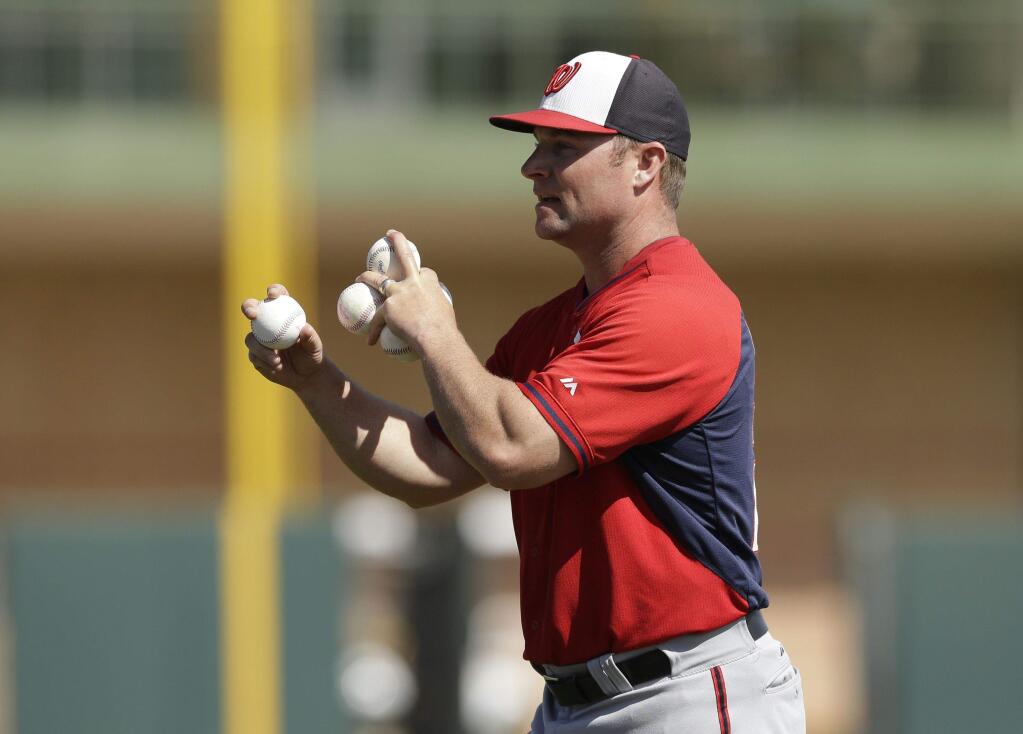 Washington Nationals hitting coach Joe Dillon throws during batting practice of a spring exhibition baseball game against the Houston Astros in Kissimmee, Fla., Sunday, March 16, 2014. (AP Photo/Carlos Osorio)