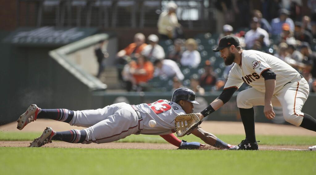 Atlanta Braves' Ronald Acuna Jr. gets picked off at first base as San Francisco Giants first baseman Brandon Belt waits for the throw from pitcher Derek Holland in the first inning of a baseball game Wednesday, Sept. 12, 2018, in San Francisco. (AP Photo/Eric Risberg)