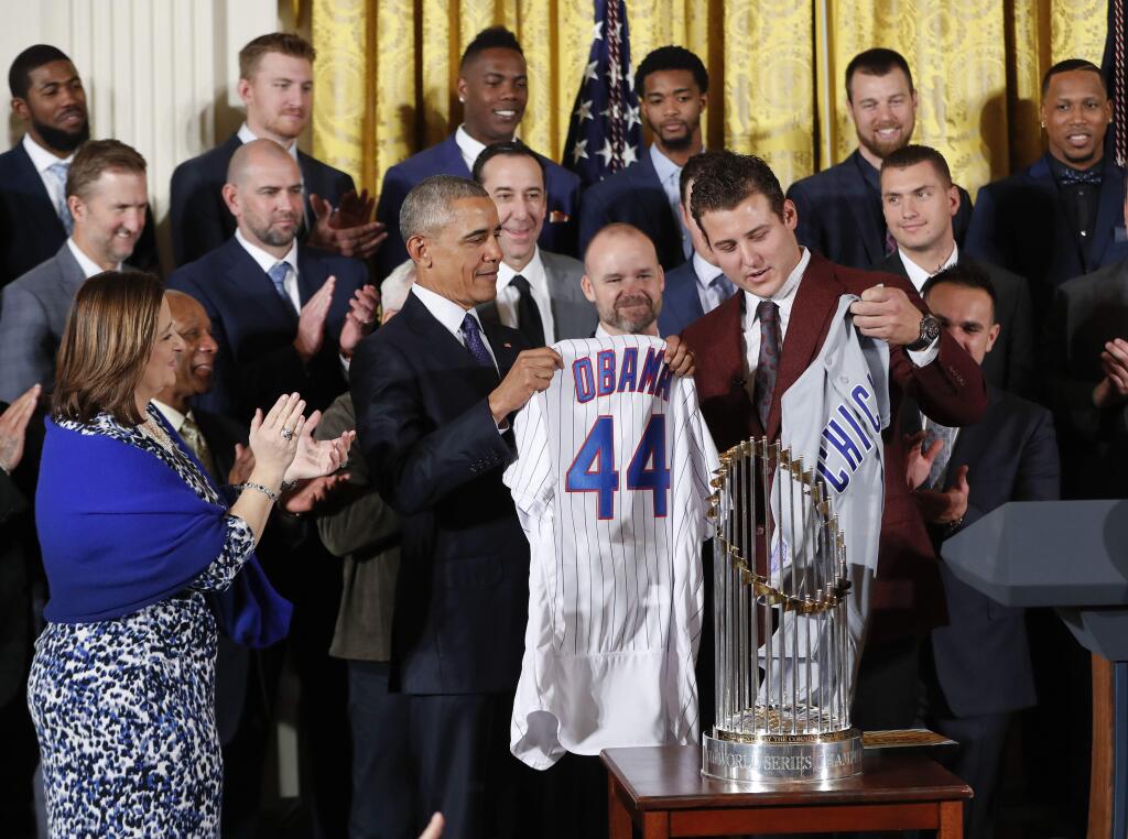 President Barack Obama holds up a personalized Chicago Cubs baseball jersey presented to him by Anthony Rizzo, right, during a ceremony in the East Room of the White House in Washington, Monday, Jan. 16, 2017, where the president honored the 2016 World Series Champion baseball team. (AP Photo/Pablo Martinez Monsivais)