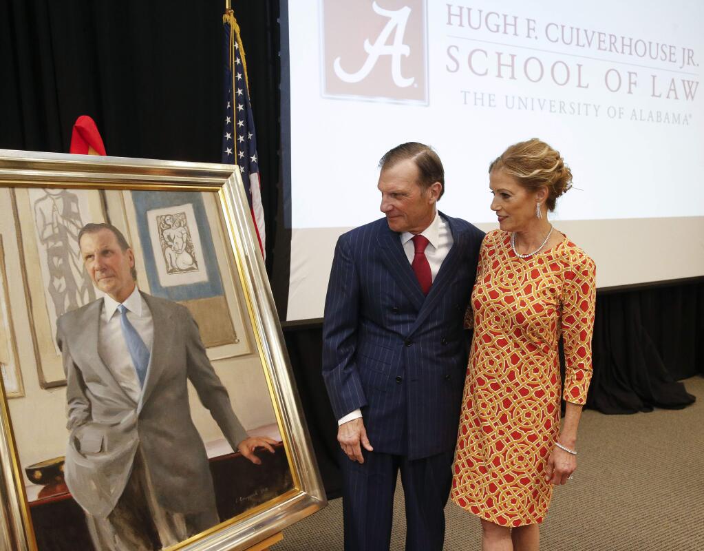 In this Sept. 20, 2018, photo, Hugh F. Culverhouse Jr. and his wife, Eliza, look at a portrait of him that will hang in the University of Alabama law school in Tuscaloosa, Ala. The university appears poised to reject a $26.5 million pledge by Culverhouse, who recently called on students to boycott the university over the state's new abortion ban. (Gary Cosby Jr./The Tuscaloosa News via AP)