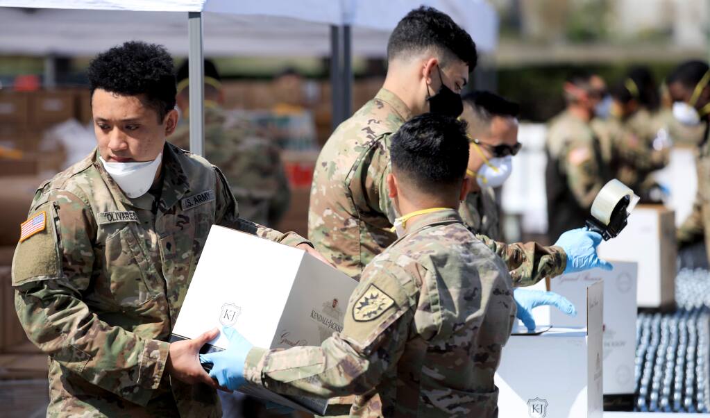 Soldiers with the National Guard pack food boxes at the Redwood Empire Food Bank, Wednesday, April 8, 2020 in Santa Rosa to help with the demand for more food deliveries around the region in response to the coronavirus pandemic. (Kent Porter / The Press Democrat) 2020