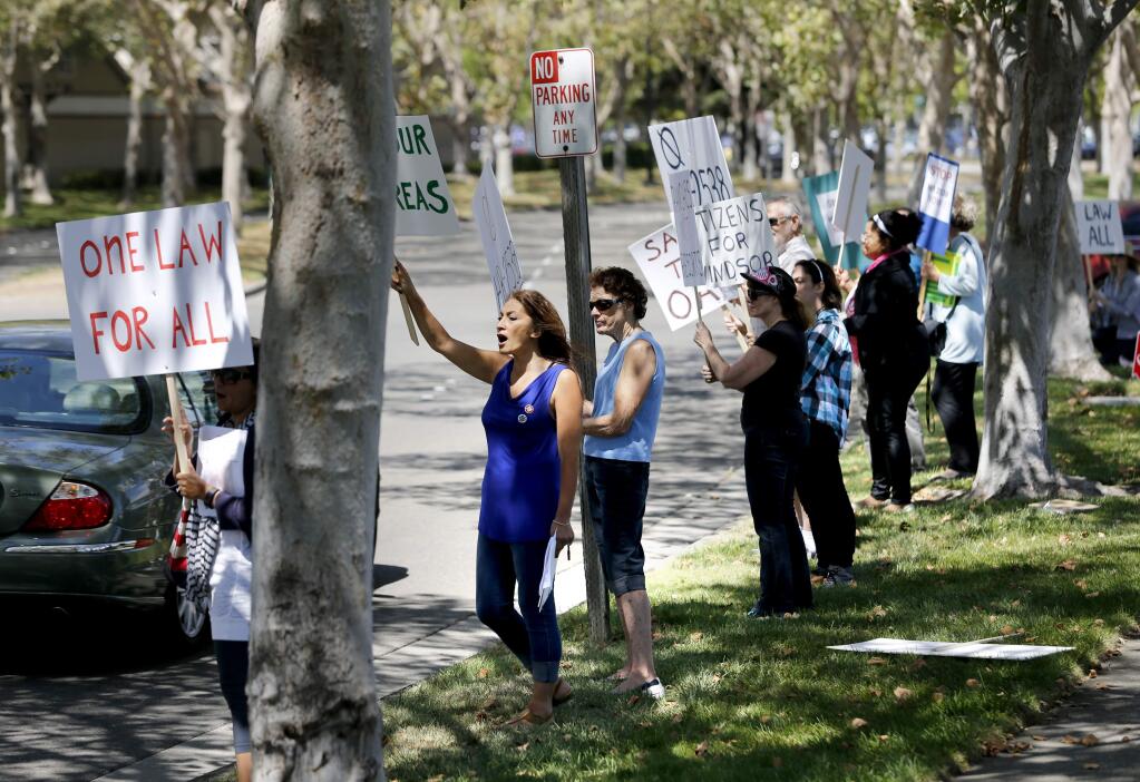 Concerned residents chant and hold signs protesting plans by Lytton Rancheria Pomos to develop an area on the west side of Windsor. Photo taken near Raley's Grocery Store in Windsor, on Friday, August 21, 2015. (BETH SCHLANKER/ The Press Democrat)
