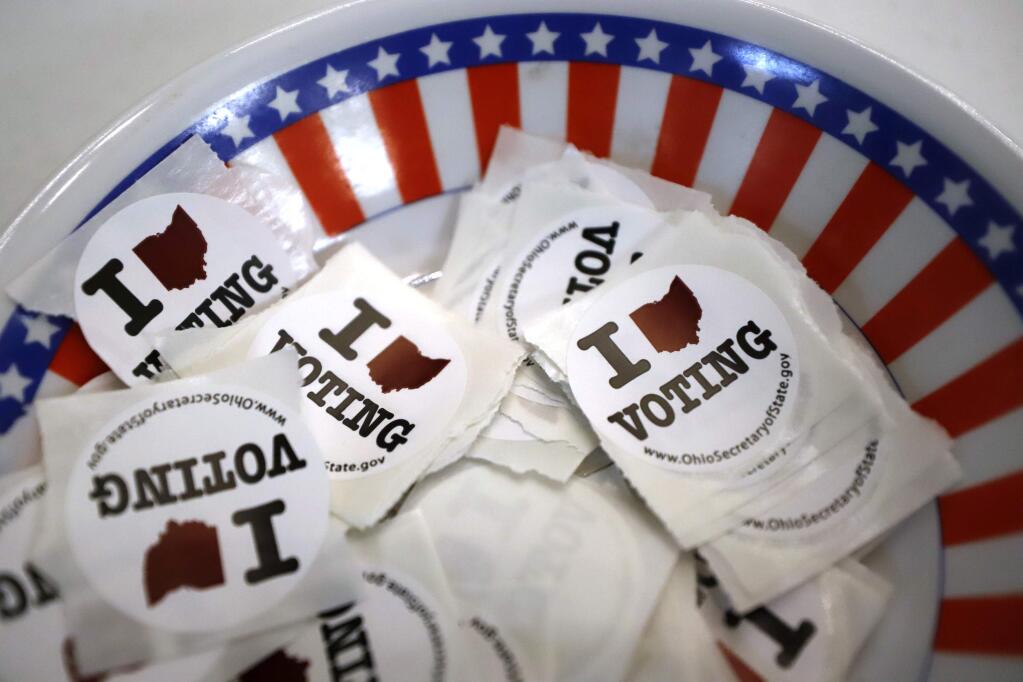 I voted stickers are seen at a polling place, Sunday, March 15, 2020, in Steubenville, Ohio. Elections officials in the four states, Arizona, Florida, Illinois and Ohio, holding presidential primaries next week say they have no plans to postpone voting amid widespread disruptions caused by the coronavirus outbreak. Instead, they are taking extraordinary steps to ensure that voters can cast ballots and polling places are clean. (AP Photo/Gene J. Puskar)