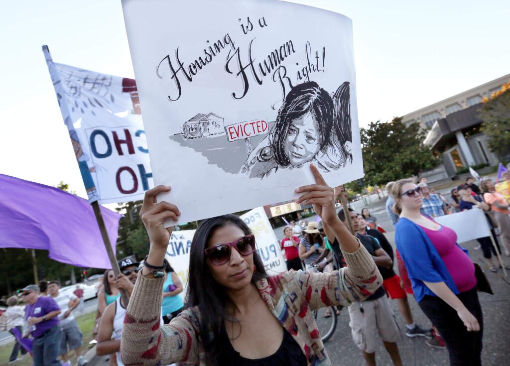 Isabel Lopez of Raizes Collective joined a few hundred people to march from Roseland Plaza to Santa Rosa City Hall in protest of the county's housing crisis, Wednesday, July 29, 2015. (Crista Jeremiason / The Press Democrat)