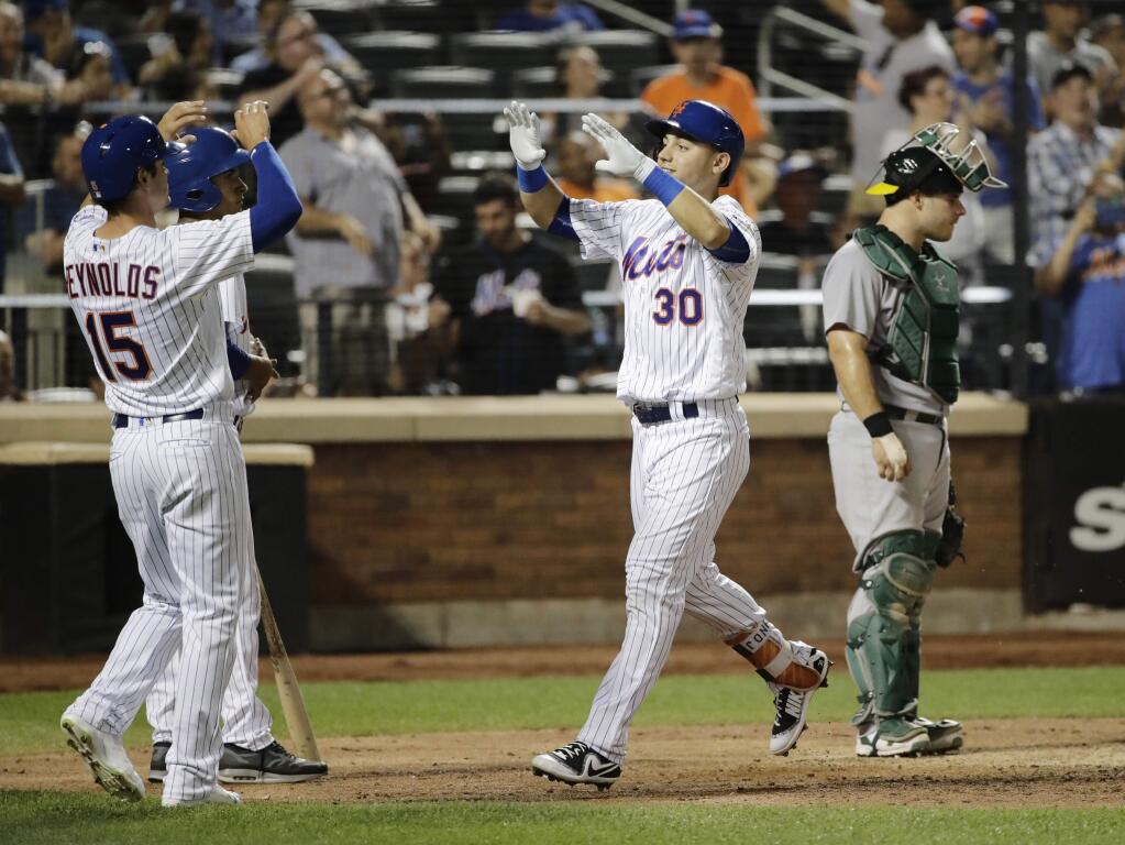 Oakland Athletics catcher Josh Phegley, right, reacts as New York Mets' Michael Conforto (30) celebrates with Matt Reynolds (15) after hitting a two-run home run during the seventh inning Friday, July 21, 2017, in New York. (AP Photo/Frank Franklin II)