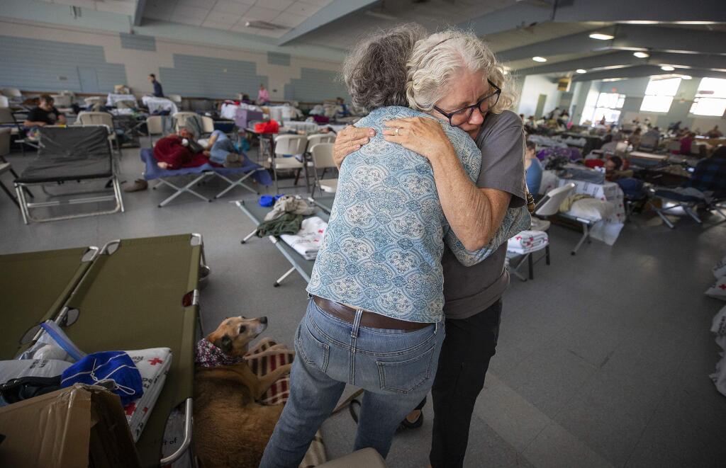 Red Cross volunteer Barbara Wood gives a hug to a Kincade fire evacuee who seemed in distress at the Red Cross shelter at the Sonoma County Fairgrounds on Sunday, Oct. 27, 2019. (JOHN BURGESS/ PD)