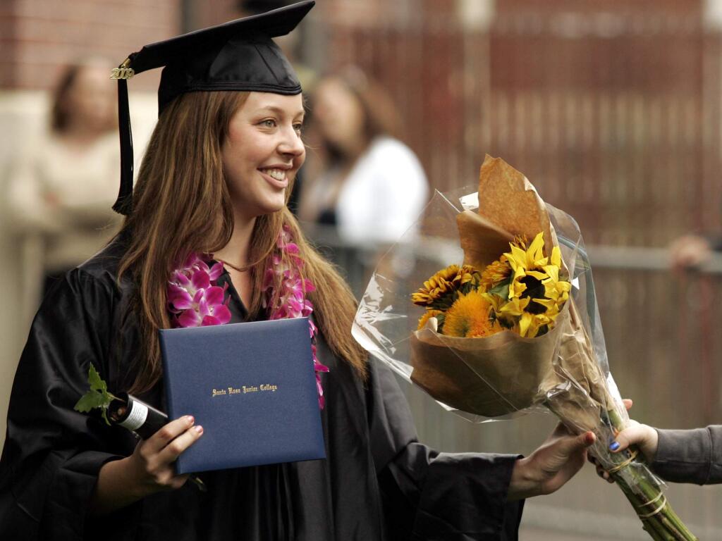 Jaime Burnside of Santa rosa receives flowers from her best friend Jesse Collins after receiving her diploma at Santa rosa Junior college's ninetieth annual Commencement at SRJC on Saturday May 23, 2009. Scott manchester / For The Press Democrat