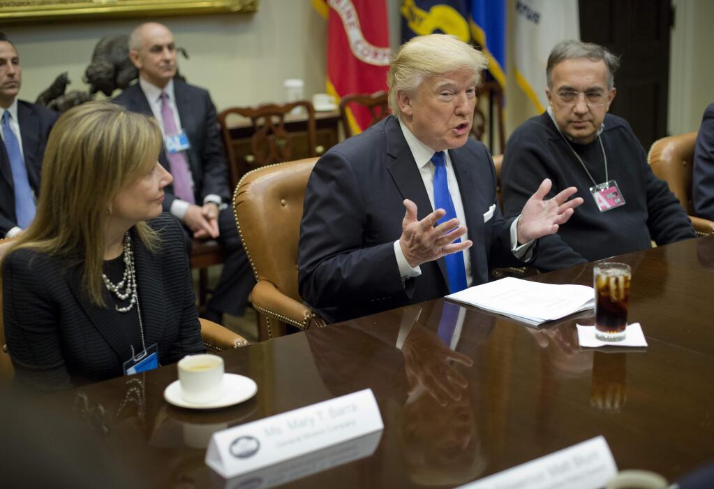 President Donald Trump, flanked by GM CEO Mary Barra and Fiat Chrysler Automobiles CEO Sergio Marchionne, gestures while speaking at the start of a meeting with automobile leaders in the Roosevelt Room of the White House in Washington, Tuesday, Jan. 24, 2017. (AP Photo/Pablo Martinez Monsivais)
