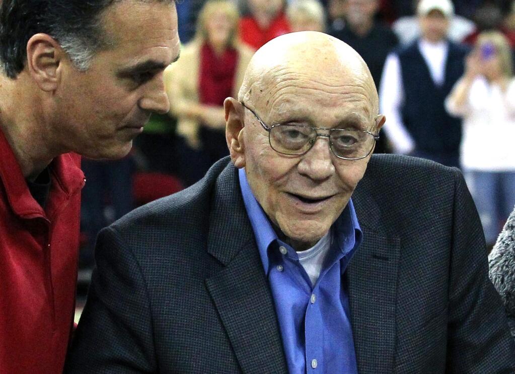 In this March 1, 2014, file photo, Jerry Tarkanian is escorted by his son, Danny, during halftime ceremonies honoring the former basketball coach at Fresno State University in Fresno, Calif. Family members say Hall of Fame basketball coach Tarkanian is hospitalized in Las Vegas with breathing trouble and some type of infection. Son Danny Tarkanian on Tuesday characterized his fathers condition as minute by minute. He says his 84-year-old father was taken by ambulance Monday, Feb. 9, 2015, to Valley Hospital Medical Center after his blood oxygen fell to dangerous levels. (AP Photo/Gary Kazanjian, File)