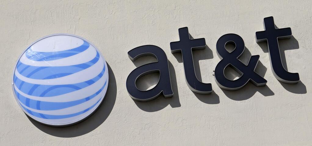 FILE - This Wednesday, Feb. 8, 2017, file photo shows the AT&T sign at a store in Hialeah, Fla. Some 17,000 AT&T workers in California and Nevada have gone on strike, the union said Wednesday, March 22, 2017. The workers install cable and phone service and work in call centers where customers can phone in with questions and problems. (AP Photo/Alan Diaz, File)