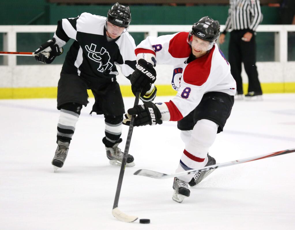 Chicago Blackhawks assistant coach Jamie Kampon, right, tries to get control of the puck while playing in Snoopy's 38th Annual Senior World Hockey Tournament in 2013. (PD FILE)