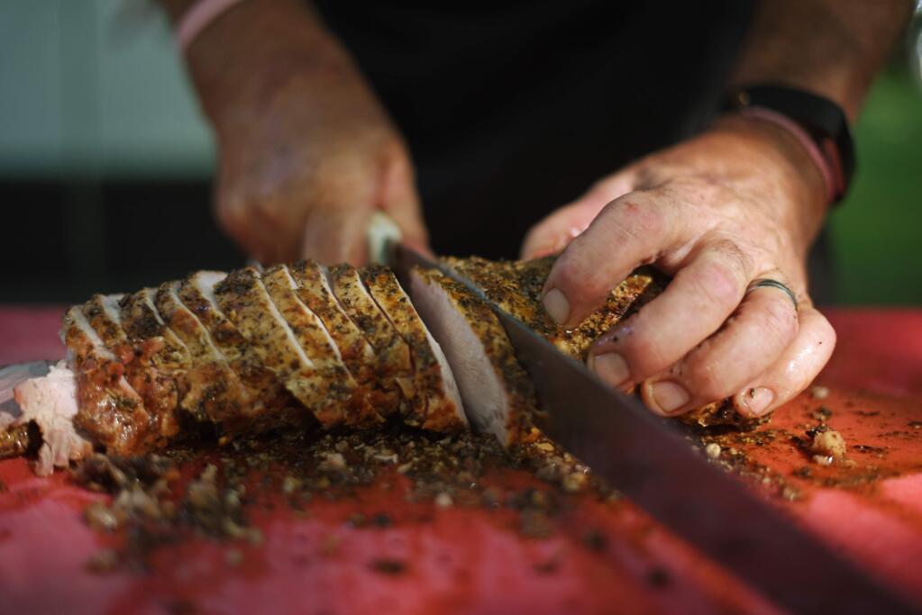 Mike Lombardi of Lombardi's Gourmet Deli and BBQ slicing up pork loin for guests during the 15th annual BBQ Fundraiser hosted by the Youth Ag & Leadership Foundation of Sonoma County at La Crema Estate at Saralee's Vineyard in Windsor on Saturday, Aug. 24, 2019. (ERIK CASTRO/ FOR THE PD)