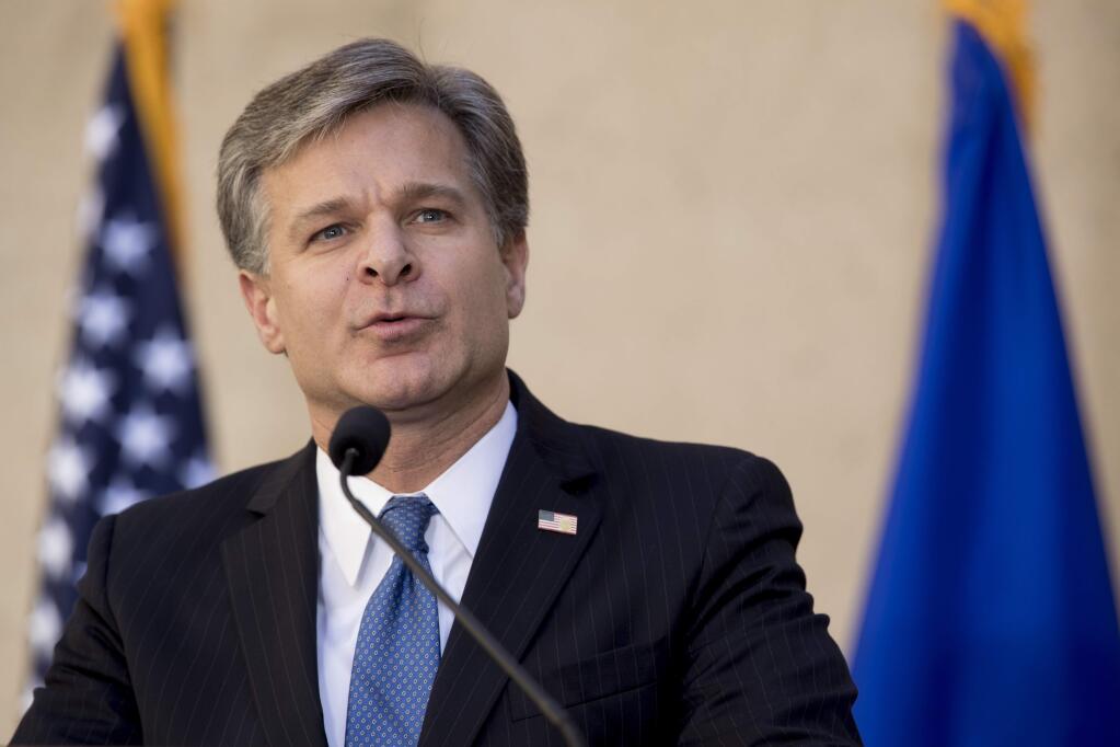 FILE - In this Sept. 28, 2017, file photo, FBI Director Chris Wray speaks at his installation ceremony at the FBI Building in Washington. Wray is dismissing Russia President Vladimir Putin's denial of election meddling. Wray said July 18, 2018, that he stands behind the U.S. intelligence agencies' assessment that Moscow did intervene. And he says Russia continues to use fake news and propaganda to stir up divisiveness in American society. (AP Photo/Andrew Harnik, File)