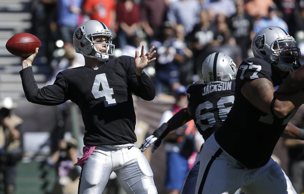 In this Oct. 12, 2014 photo, Oakland Raiders quarterback Derek Carr throws a 77-yard touchdown pass to wide receiver Andre Holmes during the first quarter of a game against the San Diego Chargers in Oakland. (AP Photo/Jeff Chiu, File)