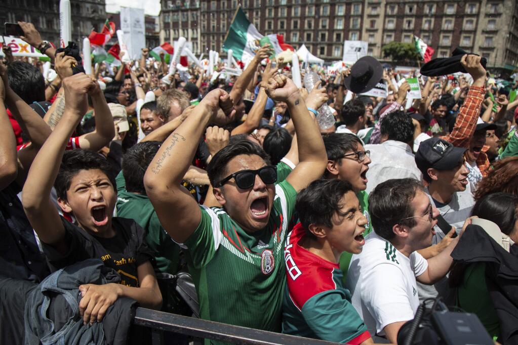 Fan's celebrate Mexico's win during the Mexico vs. Germany World Cup soccer match, as they watched it on an outdoor screen in Mexico City's Zocalo, Sunday, June 17, 2018. Mexico won it's first match against Germany 1-0. (AP Photo/Anthony Vazquez)