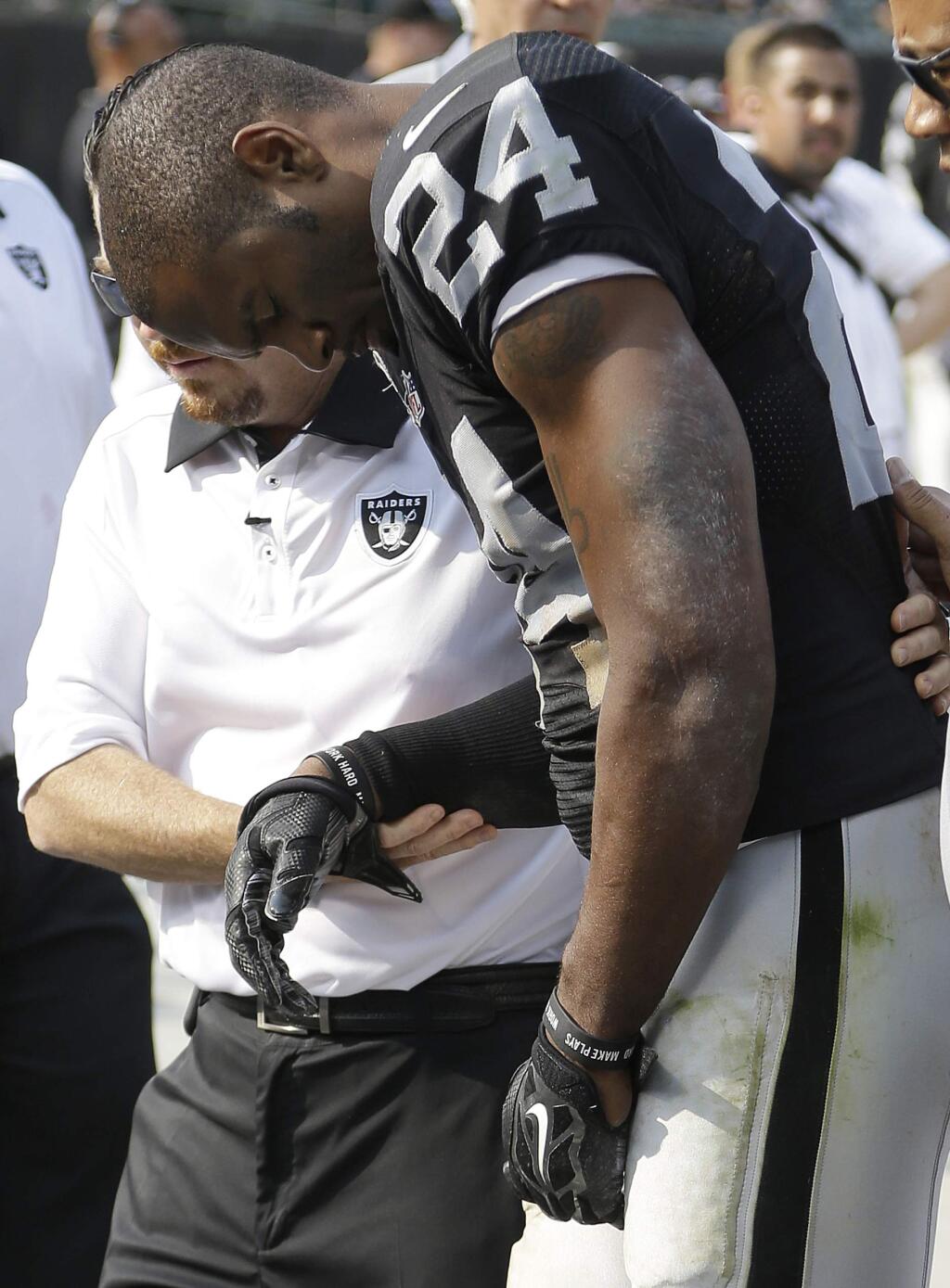 Oakland Raiders cornerback Charles Woodson (24) is helped to the sideline after being injured during the second half of an NFL football game against the Cincinnati Bengals in Oakland, Calif., Sunday, Sept. 13, 2015. The Bengals won 33-13. (AP Photo/Ben Margot)