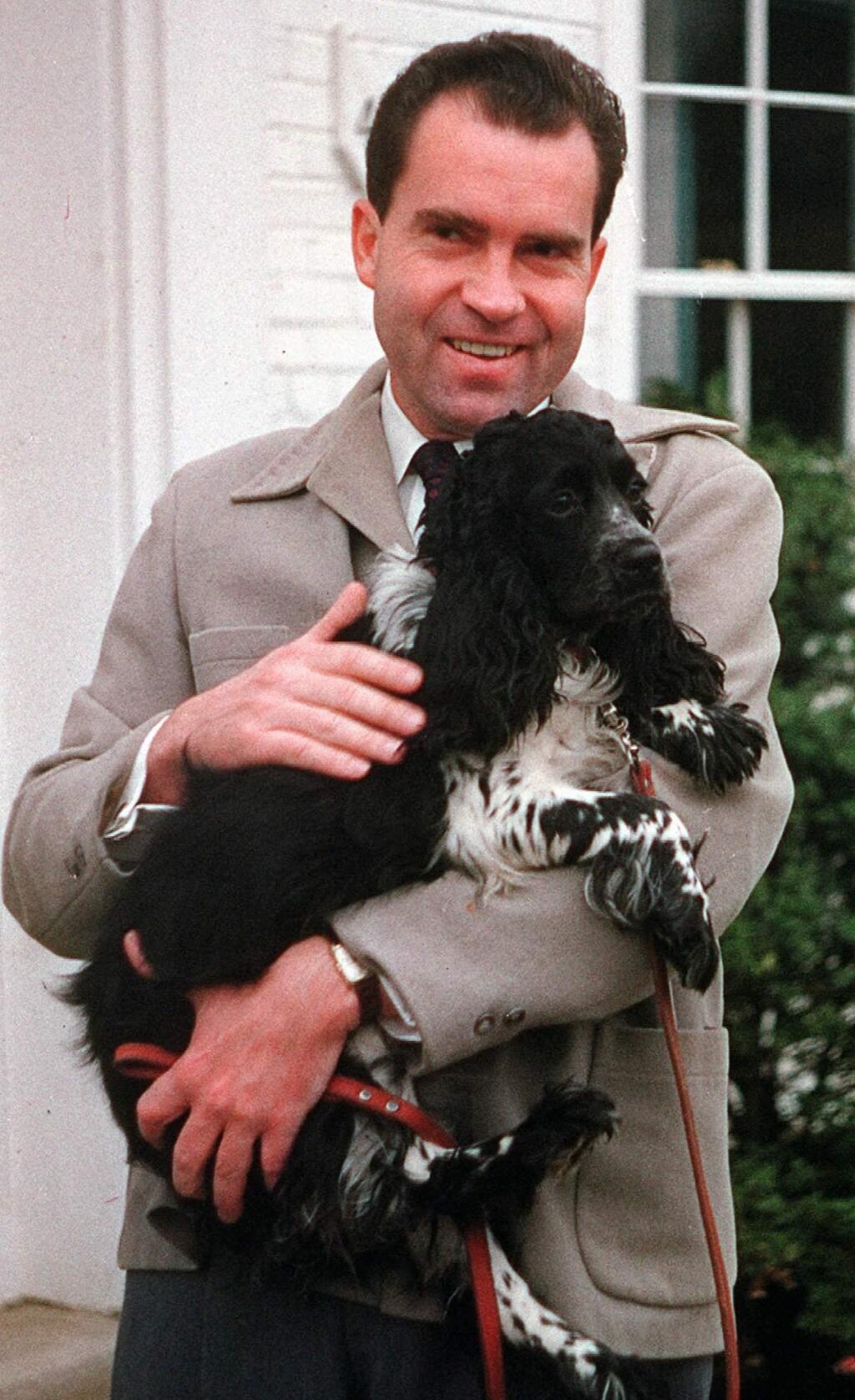 FILE-- Richard Nixon is seen with his dog 'Checkers,' at his home in Spring Valley neighborhood of Washington, DC., in this July 2, 1959 file photo. Not even a president should be separated from his faithful dog, especially if the canine helped save his political career. The body of Richard Nixon's cocker spaniel, Checkers, may be exhumed from a New York cemetery and reburied near the former president and his wife Pat in California. (AP Photo/ FILE)