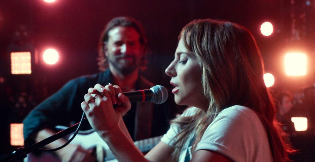 This image released by Warner Bros. shows Bradley Cooper, left, and Lady Gaga in a scene from the latest reboot of the film, 'A Star is Born.' Surely literal goosebumps are a good sign that you've just seen a pretty stunning movie moment, specifically where Lady Gaga's Ally takes a deep breath and walks out on stage to join Bradley Cooper's Jackson Maine and sing her song in front of thousands of people. (Neal Preston/Warner Bros. via AP)