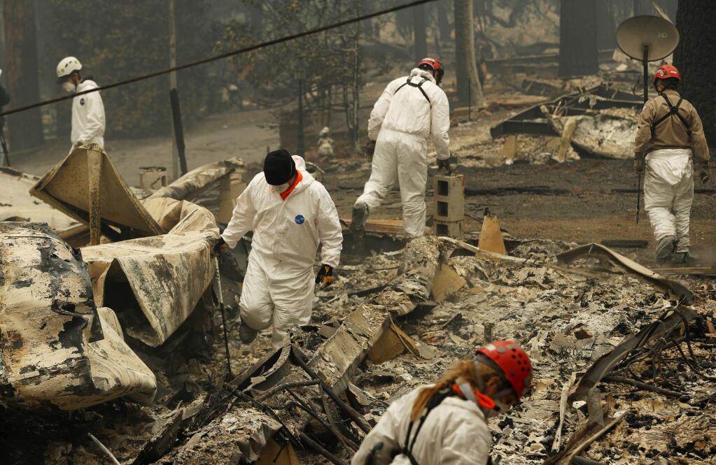 Search and rescue workers search for human remains at a trailer park burned out from the Camp Fire, Tuesday, Nov. 13, 2018, in Paradise, Calif. (AP Photo/John Locher)