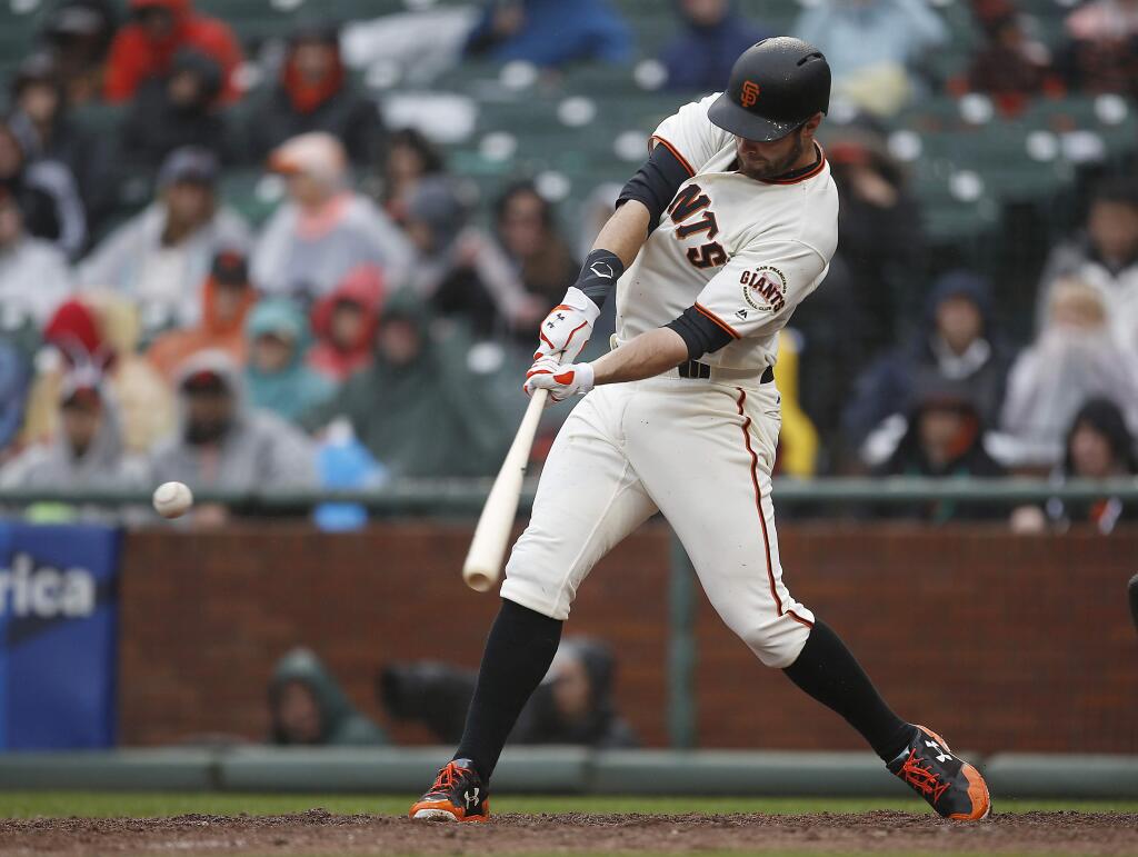 San Francisco Giants' Brandon Belt hits a double against the Colorado Rockies during the sixth inning of a baseball game, Sunday, April 16, 2017, in San Francisco. (AP Photo/Tony Avelar)