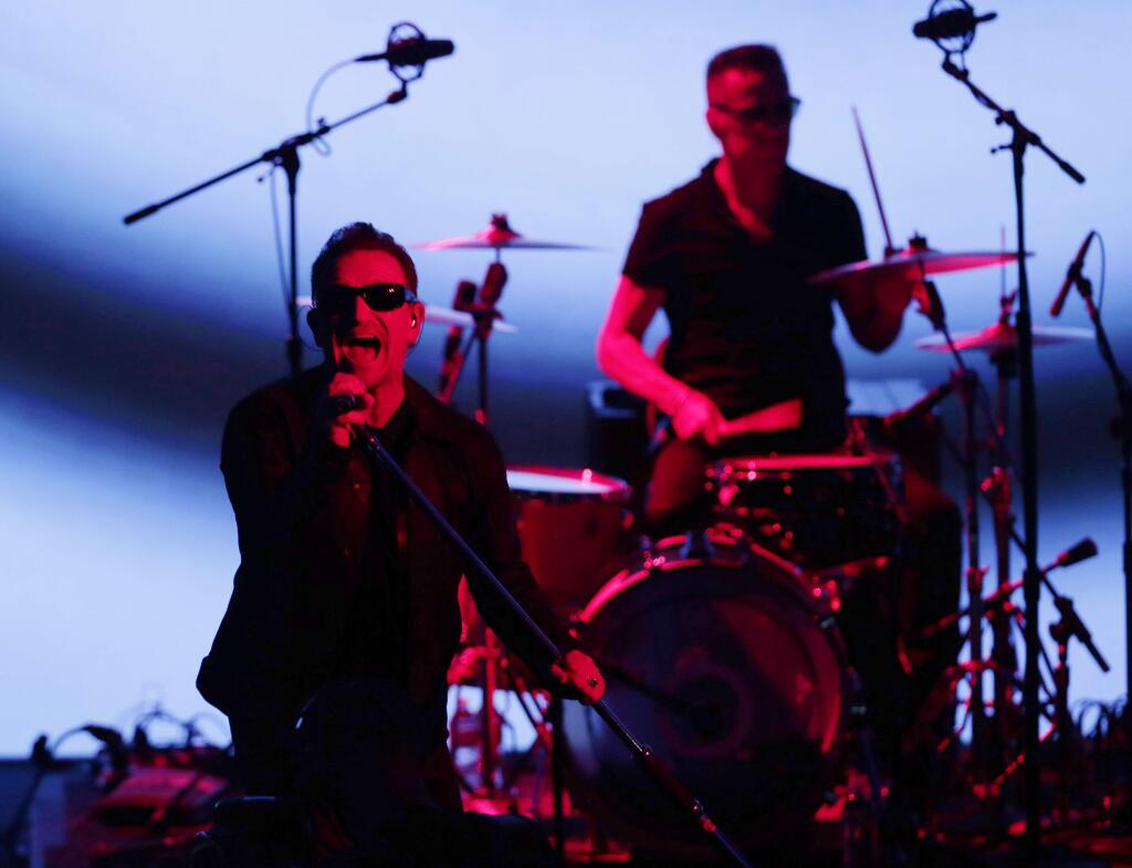 U2 members Bono, left, and Larry Mullen Jr. perform during an announcement of new products by Apple on Tuesday, Sept. 9, 2014, in Cupertino, Calif. (AP Photo/Marcio Jose Sanchez)