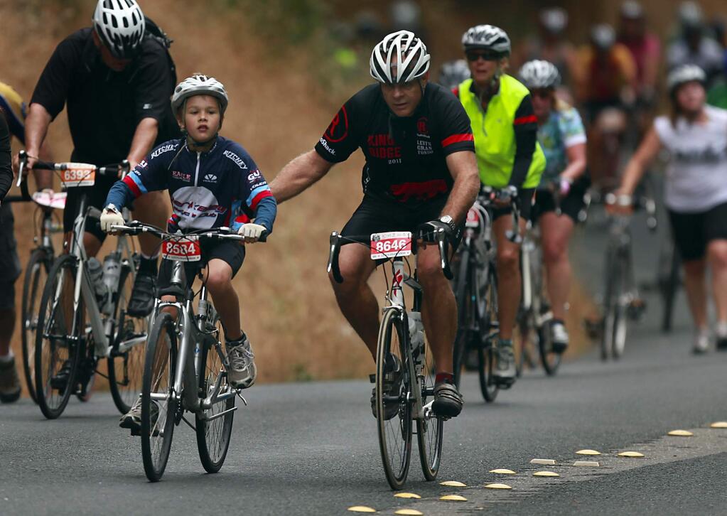 A father helps out his son as they pedal up Harrison Grade during Levi Leipheimer's King Ridge GranFondo, Saturday Oct. 1, 2011. (Kent Porter / Press Democrat)