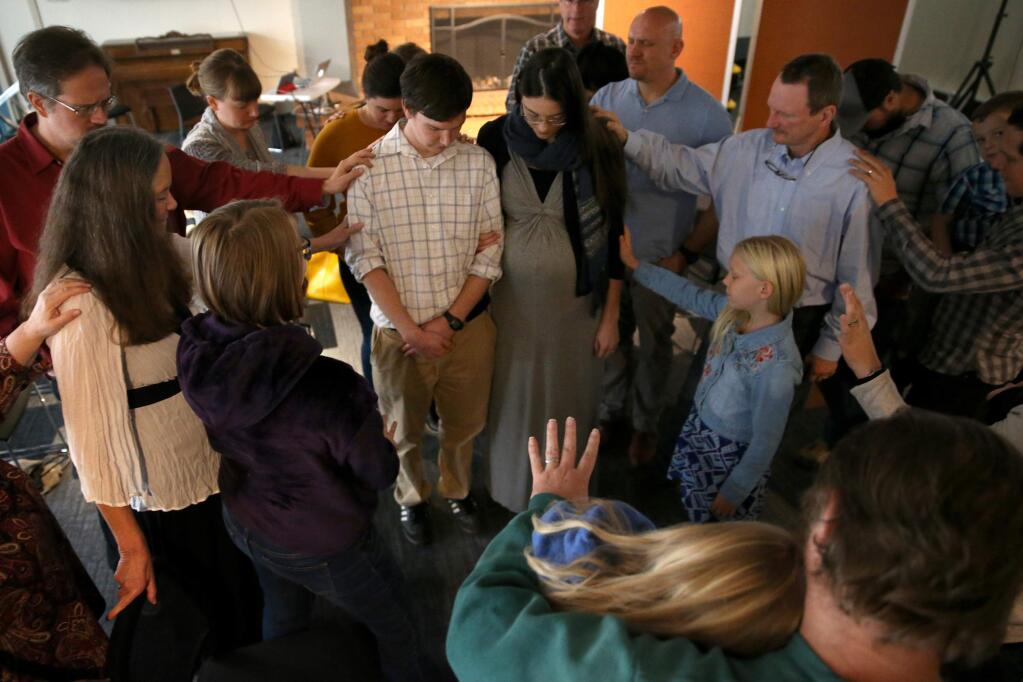Members of City Alliance Church gather around Jane and Micah Laremore to pray for them before the couple moves to Tyrone, Penn. Photo taken during a worship service held at the Steele Lane Community Center in Santa Rosa on Sunday, November 18, 2018. (BETH SCHLANKER/ The Press Democrat)