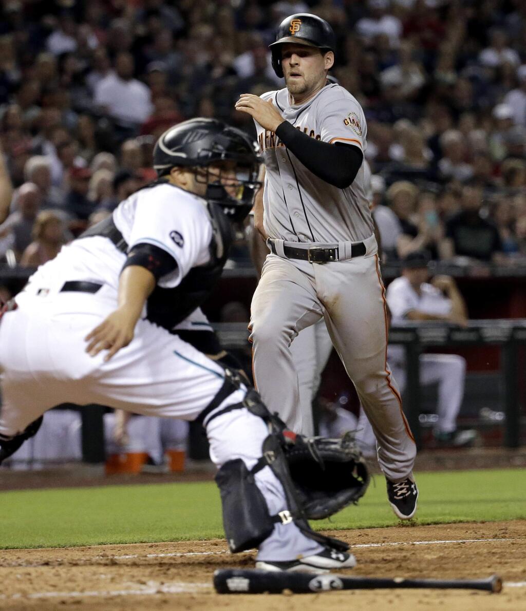 San Francisco Giants' Conor Gillaspie, right, scores on a two-RBI base hit by teammate Trevor Brown during the sixth inning of a baseball game as Arizona Diamondbacks' Welington Castillo waits for the throw, Friday, July 1, 2016, in Phoenix. (AP Photo/Matt York)
