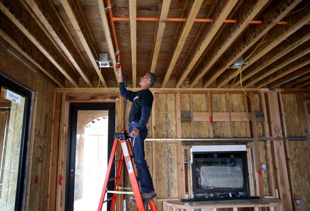 Earl Amos, an employee of All About Fire Protection, installs sprinkler heads in a Fountaingrove area home under construction in Santa Rosa on Tuesday, May 14, 2019. (BETH SCHLANKER/ PD)