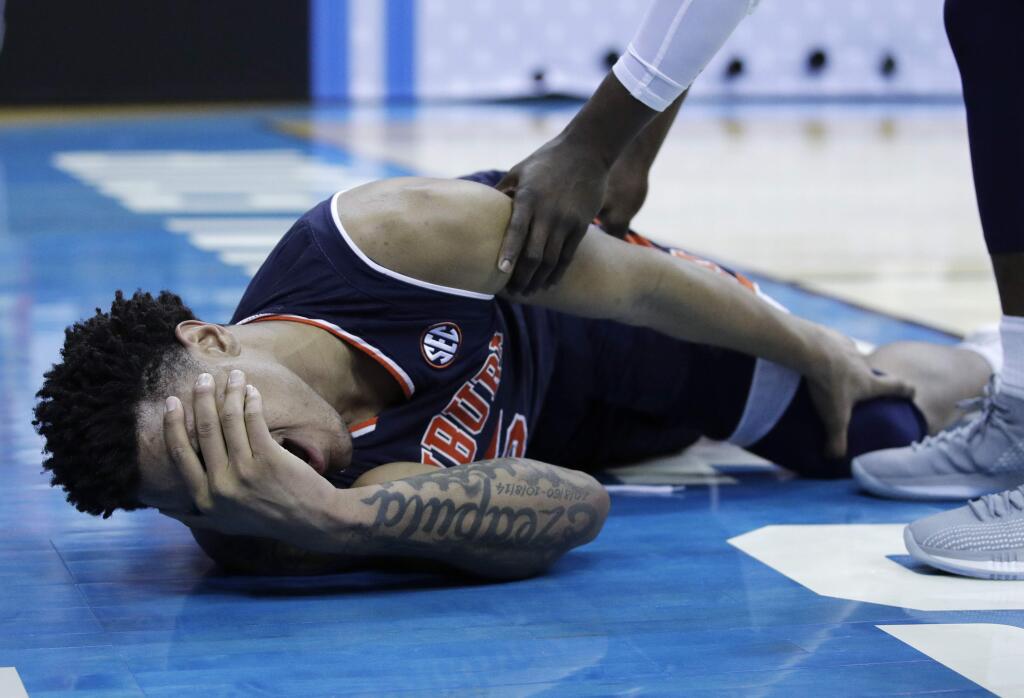 Auburn's Chuma Okeke yells out in pain after being injured during the second half of a men's NCAA tournament college basketball Midwest Regional semifinal game against North Carolina Friday, March 29, 2019, in Kansas City, Mo. (AP Photo/Charlie Riedel)
