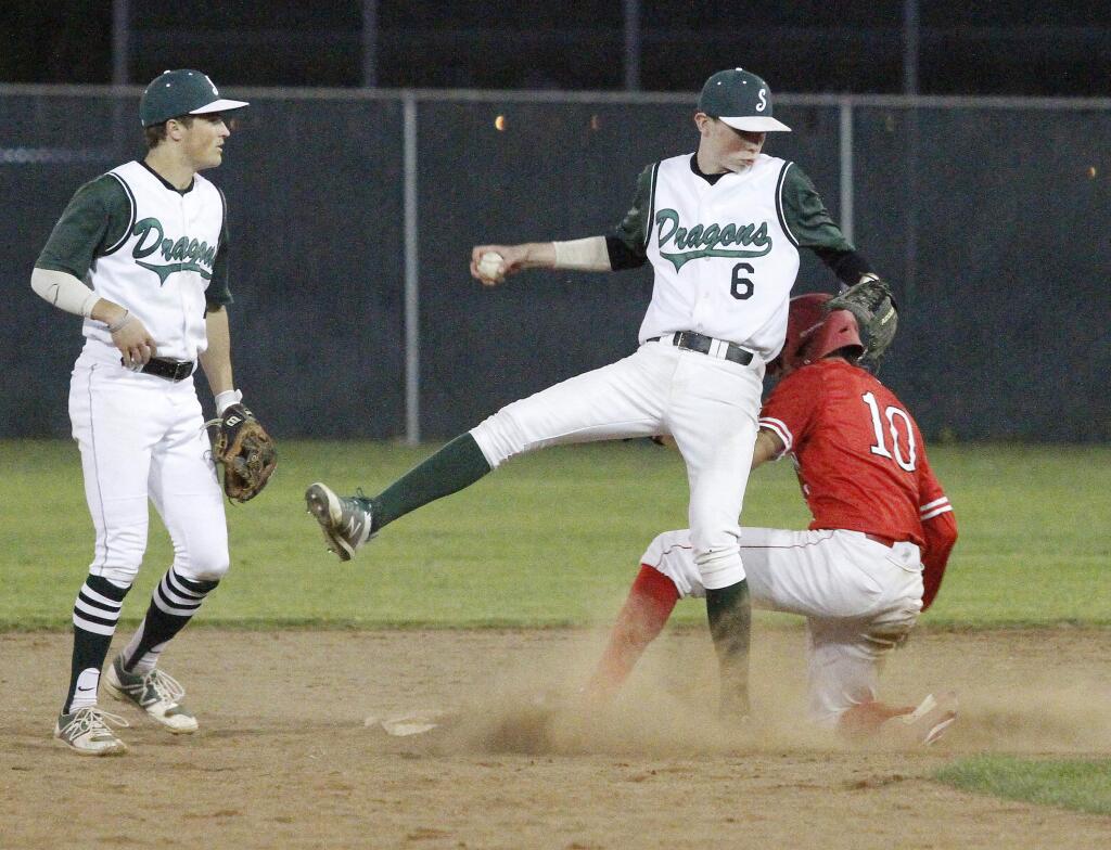 With teammate Max Handron looking on, Jack Boydell is almost upended by a runner sliding into second base during a May 2018 game against El Molino. Handron is returning to Dragons baseball this year, but Boydell has just finished basketball season and will not rejoin the team.(Bill Hoban/Index-Tribune File)