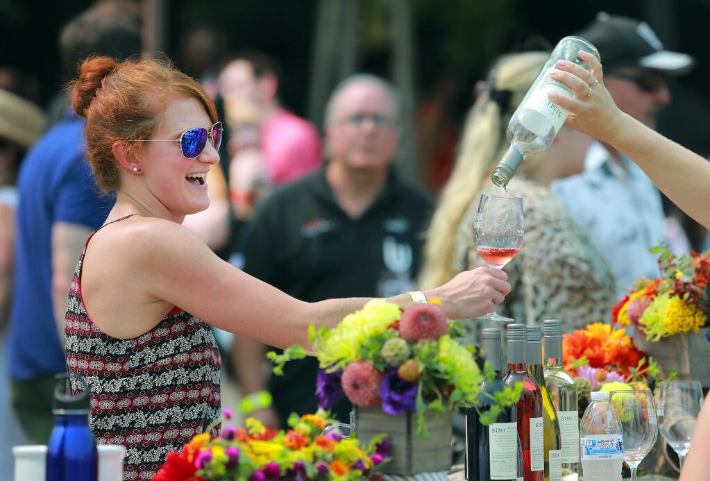 Amy Babiuch of Cleveland holds her glass out for the last drop of a rose at the Taste of Sonoma at the Green Music Center on the SSU campus on Saturday, September 2, 2107. (photo by John Burgess/The Press Democrat)