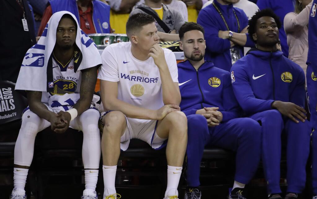 Golden State Warriors' Alfonzo McKinnie, from left, sits on the bench with Jonas Jerebko, Klay Thompson and Damian Jones during the second half of Game 3 of the NBA Finals against the Toronto Raptors in Oakland, Wednesday, June 5, 2019. (AP Photo/Ben Margot)
