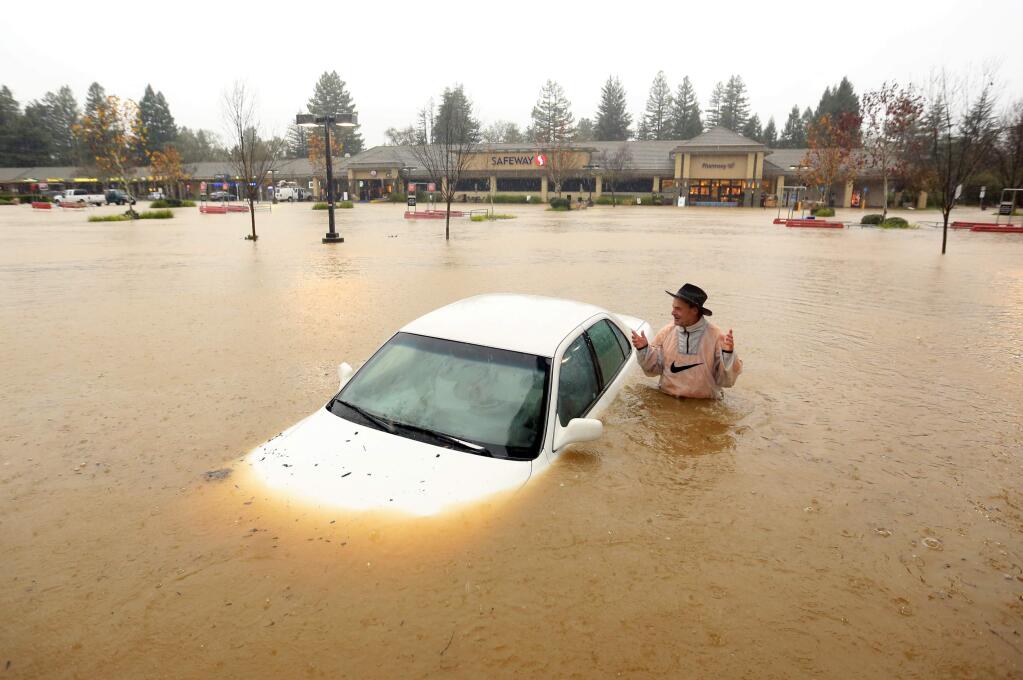 Gary of Guerneville, parked his car in the Safeway parking lot overnight and came back to find his car flooded in Healdsburg on Thursday, December 11, 2014. This photo took first place in the news photo category of the San Francisco Peninsula Press Club's annual journalism contest. (Kent Porter / PD)