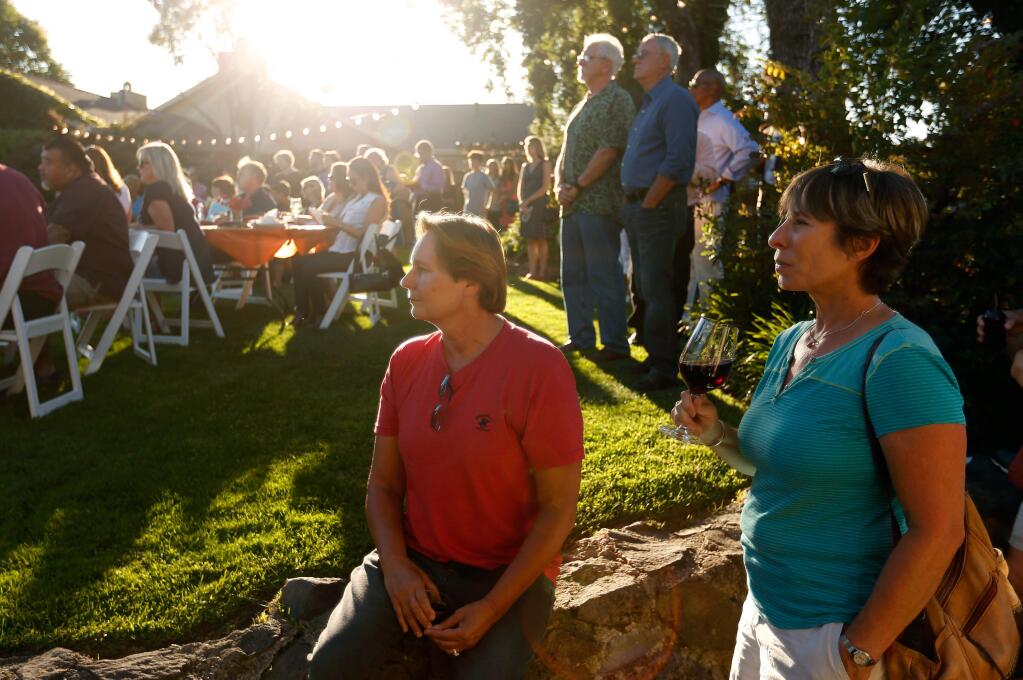 Friends Rhonda Ross of Santa Rosa, left, and Emily Hamilton of Healdsburg listen to speakers during a benefit for victims and families of the Pulse nightclub shooting, at Healdburg Golf Club in Healdsburg, California on Wednesday, June 22, 2016. (Alvin Jornada / The Press Democrat)